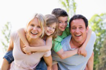 A family standing together, with their children on the parents backs