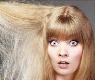 A lady holding her hair out and it looks very frizzy