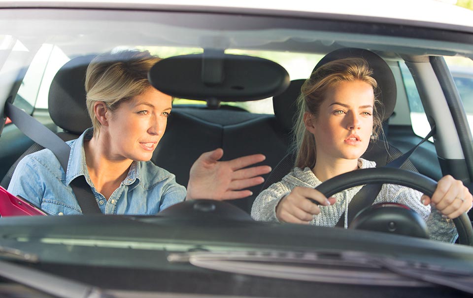 a mom explaining something to her teenage driver daughter