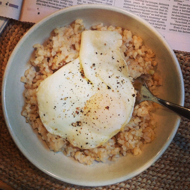 A picture of some eggs over rice, seasoned atop the eggs