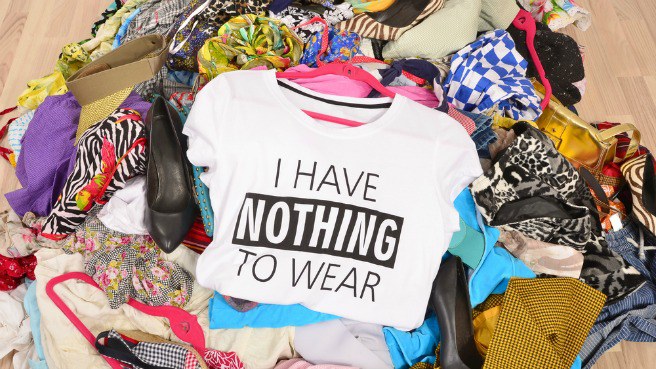 A big pile of clothing with a shirt on top that says I have nothing to wear