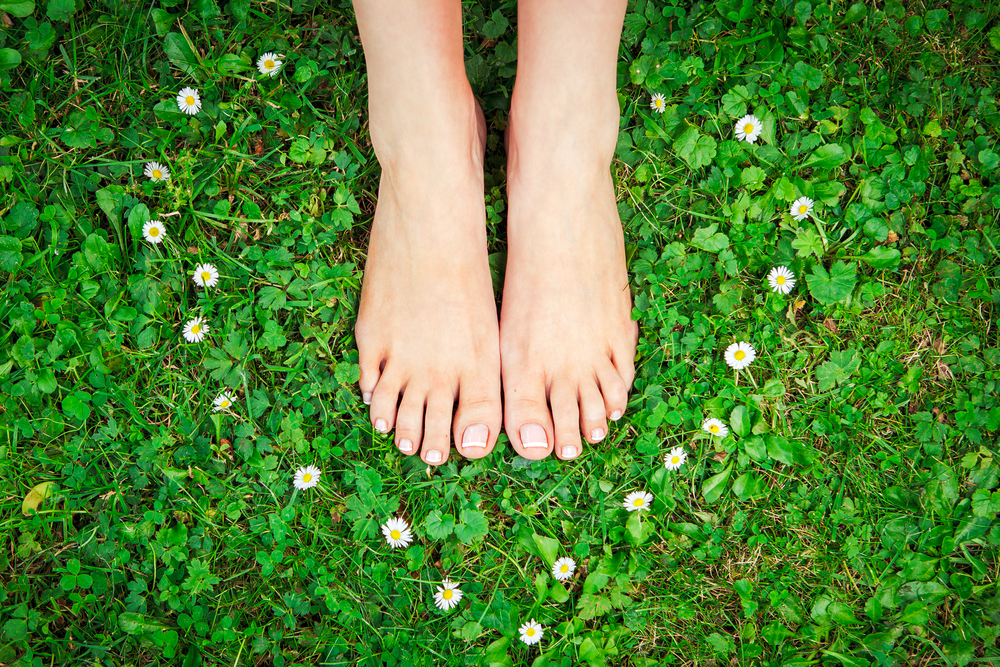 Feet on the grass, surrounded by a heart of flowers