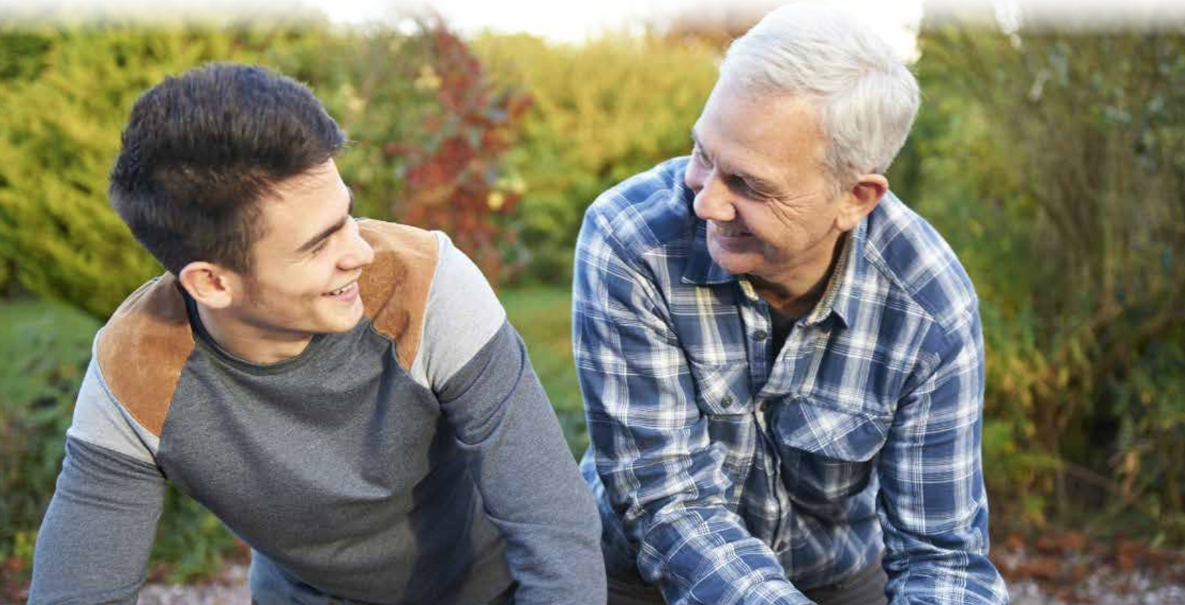 A man and his son looking at each other and smiling