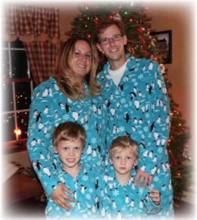 A family standing in front of a christmas tree in matching pajamas