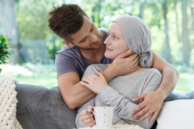 A man holding a women closely, she has a mug in her hand