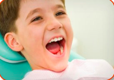 A boy at the dentists office with a big open smile