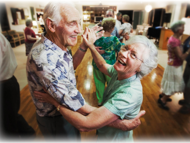 An elderly man and his wife dancing together at a party