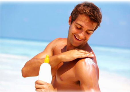 A man putting sun block on at the beach