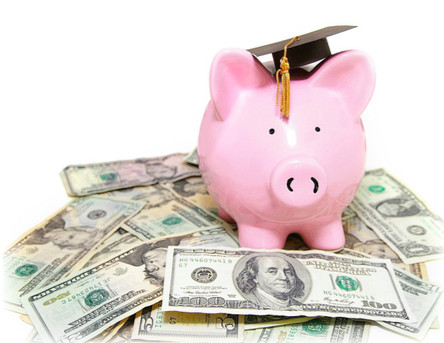 A piggy bank with a graduation cap on sitting on top of money