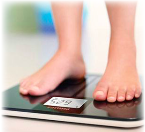 Feet standing on a scale being weighed