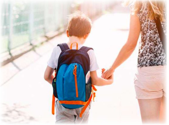 A boy with a backpack on holding his mothers hand