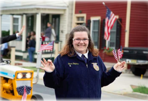 a girl holding mini american flags, with a big smile