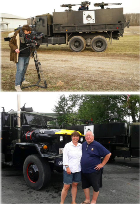 A man standing next to a gun truck, a man and women standing together in front of a gun truck