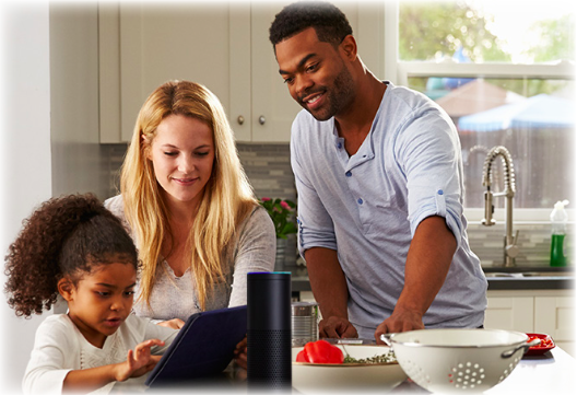A family standing together, watching their daughter play on an ipad