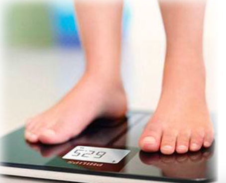 Feet standing on a scale being weighed