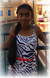 a girl standing in front of a fence in a zebra print dress
