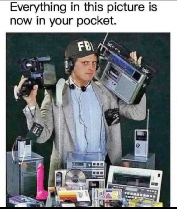 man holding numerous old technologies, related to how now all of it is in the pal of your hand on a phone