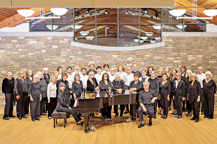 A choir and a pianist standing together for a group photo