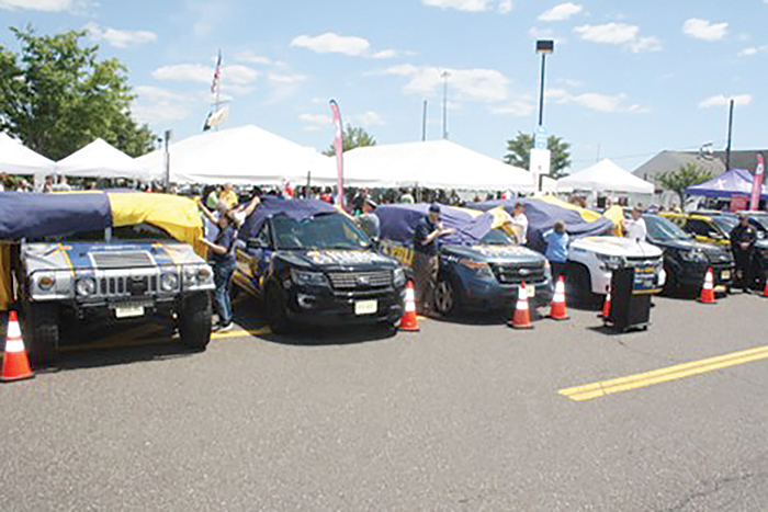 A bunch of cars lined up together with flags draped over them