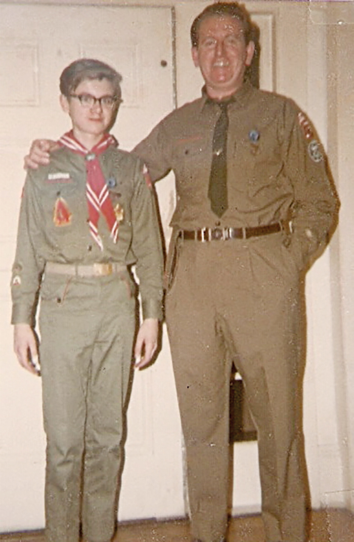 An older photo of a man and his son standing in boy scouts attire