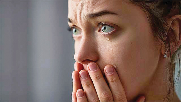 A closeup of a lady with her eyes tearing up