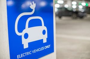 A sign that reads "electric vehicles only" with a blue backing