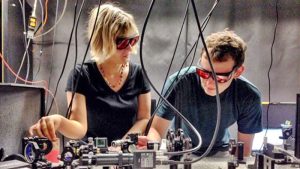 A man and women in front of scientific looking equipment