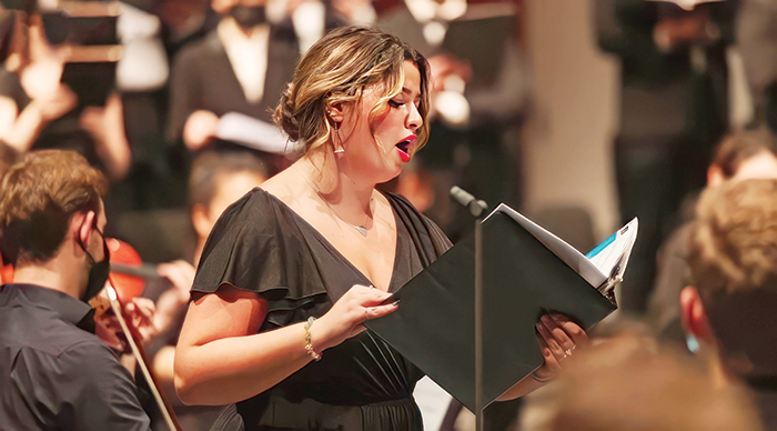 A lady singing opera amongst the orchestra