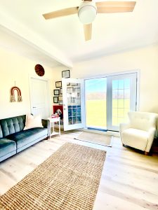 The waiting room of an office, with a modern and bright twist, with a door directly to grass outside