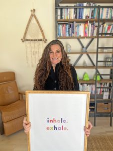 Dr. Spada holding a picture that reads "inhale. exhale."