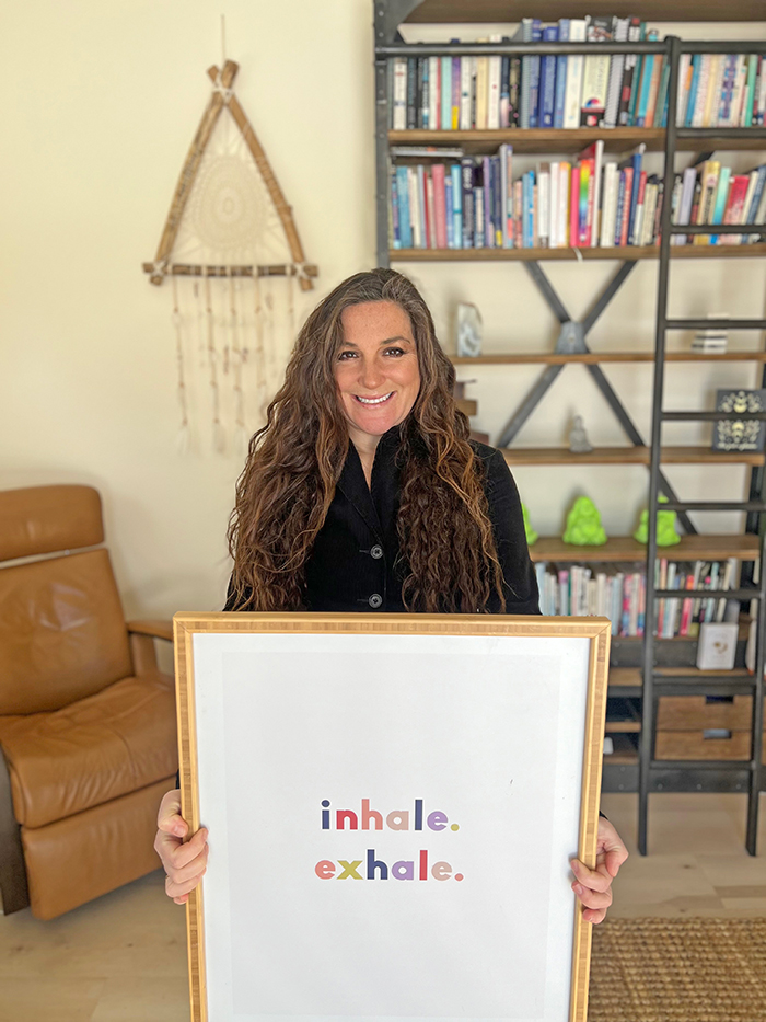 Dr. Spada holding a picture that reads "inhale. exhale."