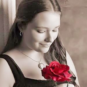 A girl holding a red rose, staring at it intently.